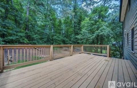 A wooden deck overlooks a forest.