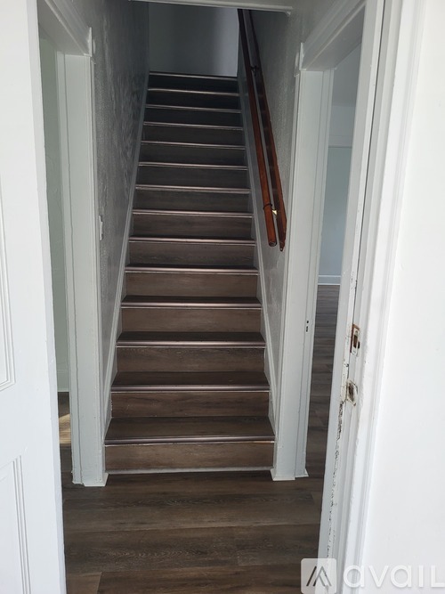 A staircase with wooden steps and white walls.