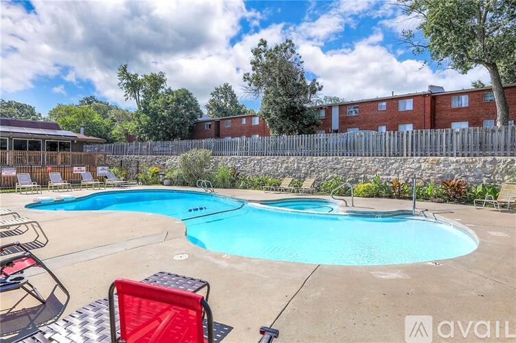 A swimming pool with a red chair and a fence in the background.