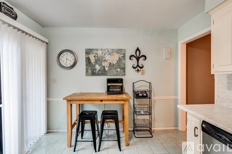 A kitchen with a wooden table and black stools.