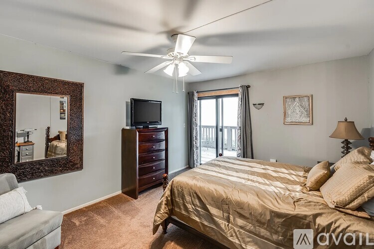 A bedroom with a bed, dresser, and television.