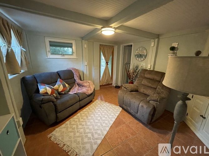 A living room with a grey couch and a brown armchair.