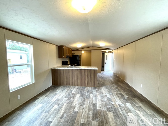 A spacious room with a wooden counter and grey flooring.
