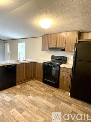 A kitchen with wooden cabinets and black appliances.