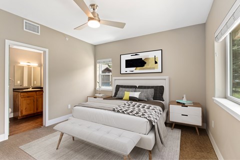A bedroom with a bed, nightstand, and a ceiling fan.