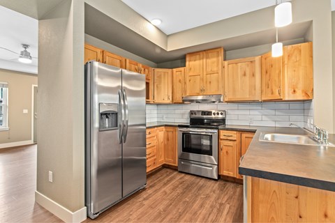 A modern kitchen with wooden cabinets and stainless steel appliances.