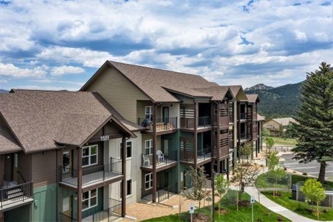 Apartment complex with balconies and a mountain in the background.