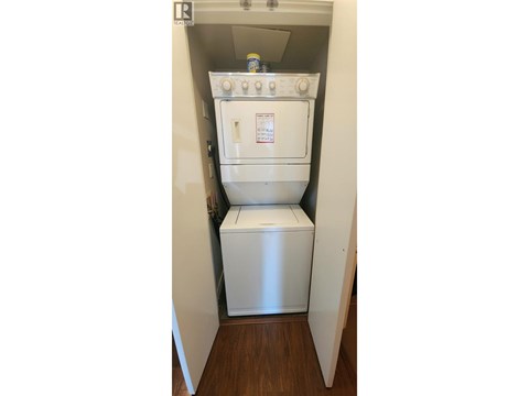 A white oven and microwave are installed in a small kitchen.