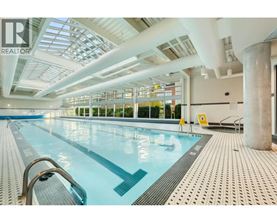 A large indoor swimming pool with a glass ceiling.