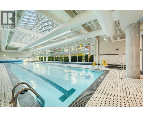 A large indoor swimming pool with a glass ceiling.