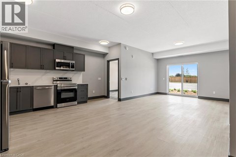 A spacious kitchen with dark brown cabinets and stainless steel appliances.
