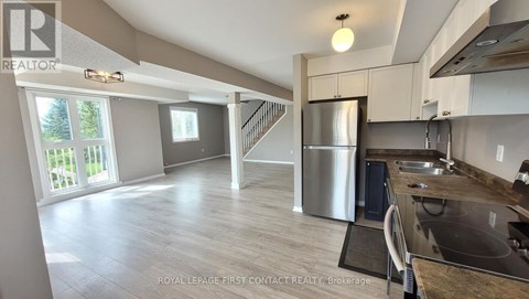 A kitchen with a stainless steel refrigerator and a sink.