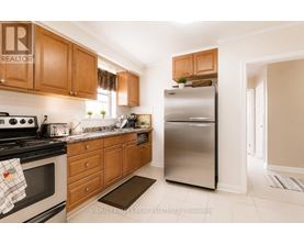 A kitchen with wooden cabinets and a stainless steel refrigerator.