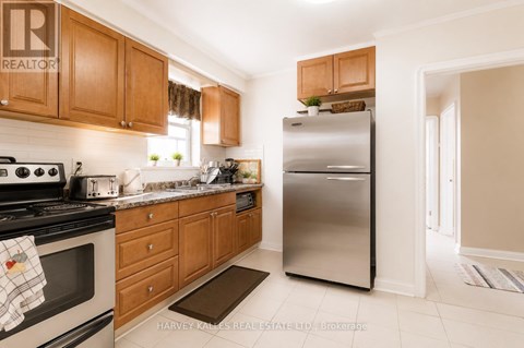 A kitchen with wooden cabinets and a stainless steel refrigerator.