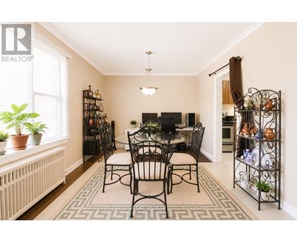 A dining room with a table set for four.