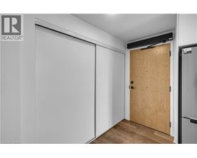 A room with a wooden door and a white wall.