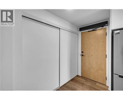 A room with a wooden door and a white wall.