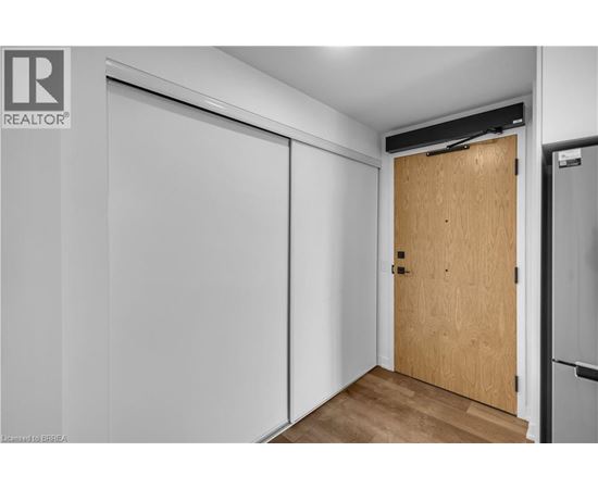 A room with a wooden door and a white wall.