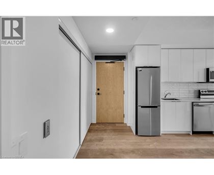 A kitchen with white cabinets and a wooden door.