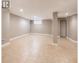 A spacious empty room with beige tiled flooring and white walls.