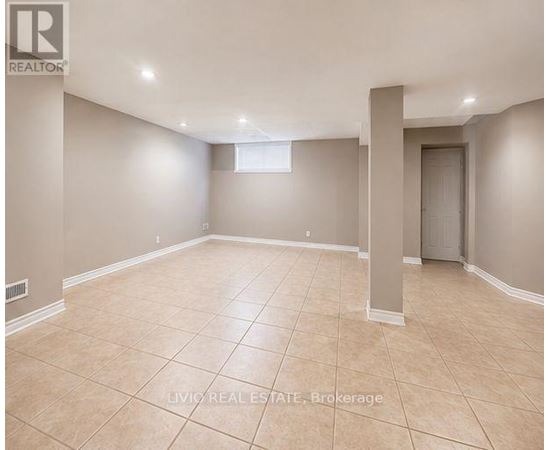 A spacious empty room with beige tiled flooring and white walls.