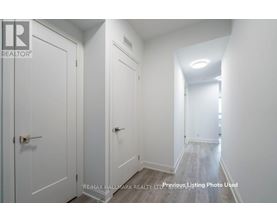 A hallway with white doors and a light on the ceiling.