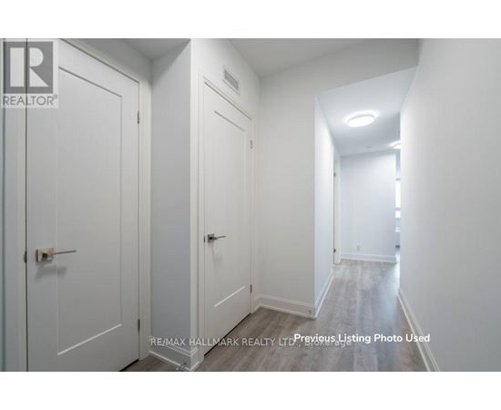 A hallway with white doors and a light on the ceiling.