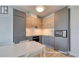 A kitchen with a table and chairs in front of a refrigerator and microwave.