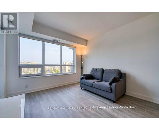 A living room with a grey couch and a large window.