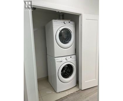 Two white washing machines in a small cabinet.