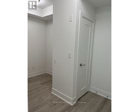 A white door is on the right side of a room with wood flooring.