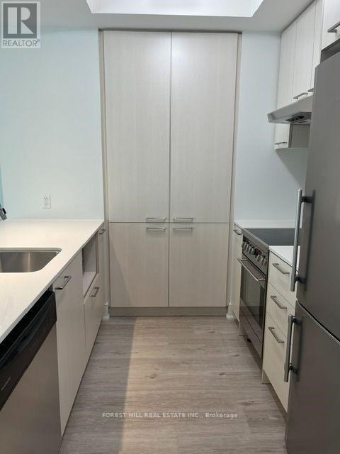 A kitchen with white cabinets and a refrigerator.