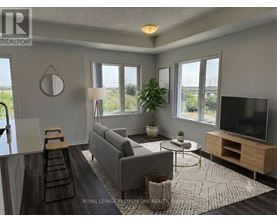 A living room with a grey couch, a wooden coffee table, and a flat screen TV.