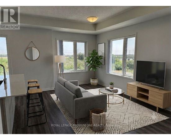 A living room with a grey couch, a wooden coffee table, and a flat screen TV.