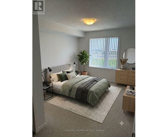 A bedroom with a bed, nightstand, and a plant.