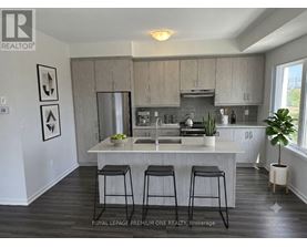 A kitchen with a bar stool in front of it.