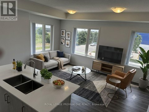 A well-lit, modern kitchen and living room with a dining table and chairs.