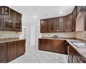 A kitchen with brown cabinets and a marble floor.