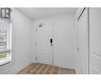A white door with a window to the left and a wall to the right.