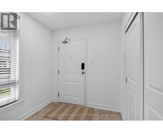 A white door with a window to the left and a wall to the right.
