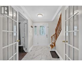 A hallway with a white door and a staircase.
