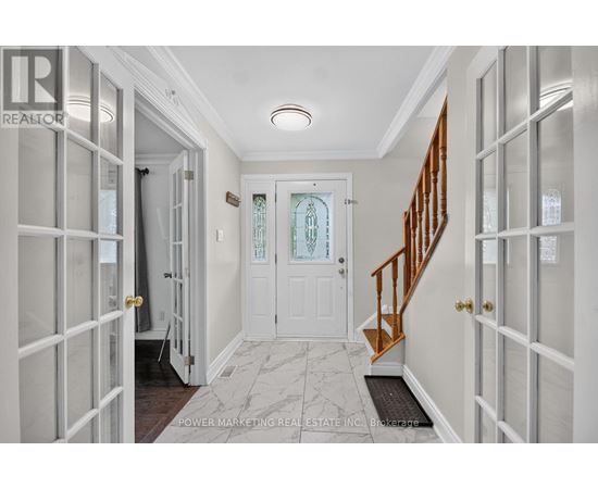 A hallway with a white door and a staircase.
