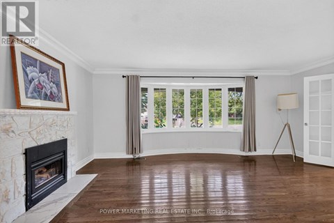 A living room with a fireplace and a painting on the wall.