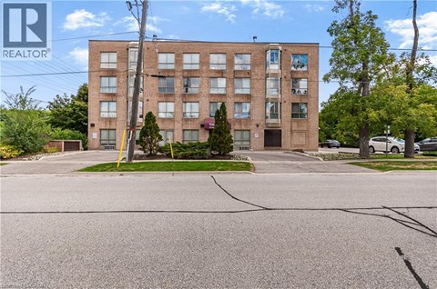 A large brick building with a parking lot in front.