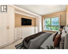 A bedroom with a large bed and a flat screen TV mounted on the wall.