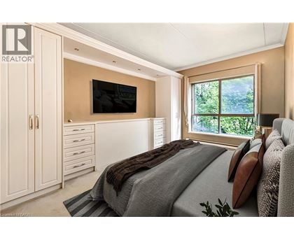 A bedroom with a large bed and a flat screen TV mounted on the wall.