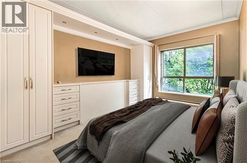 A bedroom with a large bed and a flat screen TV mounted on the wall.