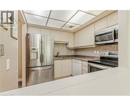 A kitchen with a stainless steel refrigerator and white cabinets.