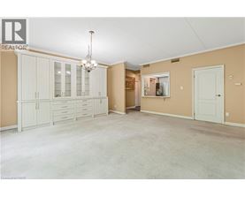 A spacious room with a chandelier and a cabinet with glass doors.
