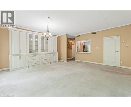 A spacious room with a chandelier and a cabinet with glass doors.